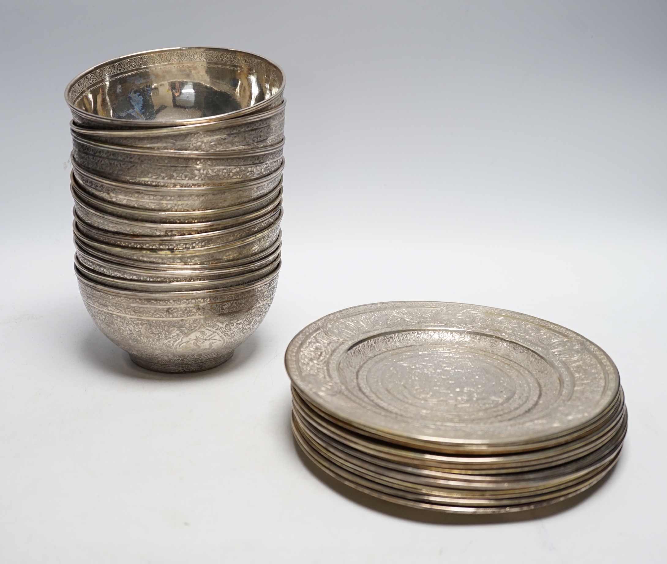 A set of twelve Persian engraved white metal bowls and matching stands/side plates?, bowl diameter 112.8cm, 146.7oz.